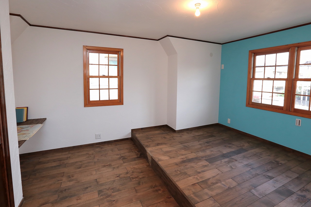 2階の主寝室。無垢材と漆喰、アクセントのブルーの塗装がさわやかな空間。
