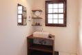 無垢材で作ったかわいらしい洗面台。壁面に取り付けた拡大鏡や飾り棚でホテルライクな暮らしを