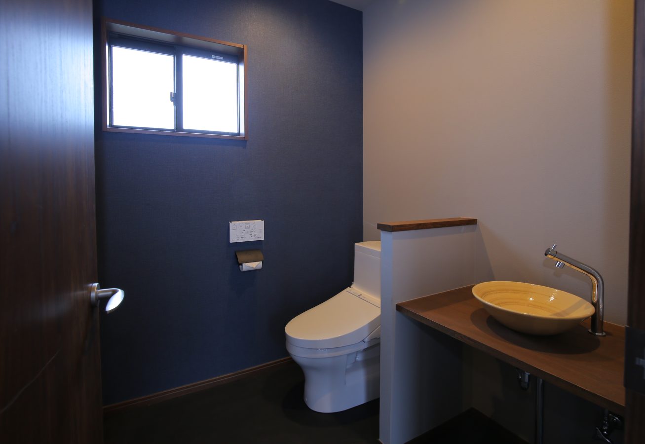 カフェのトイレスペース、器のような手洗器と藍色の壁面が映えます。